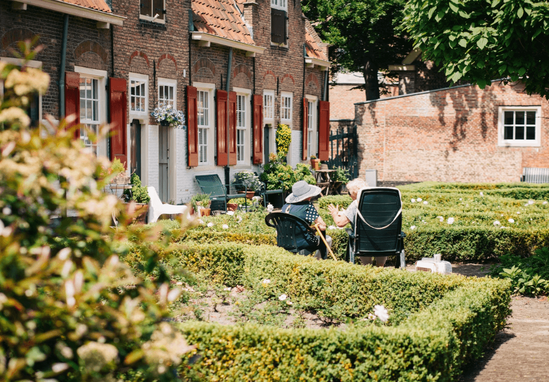 older friends sat in garden having a conversation