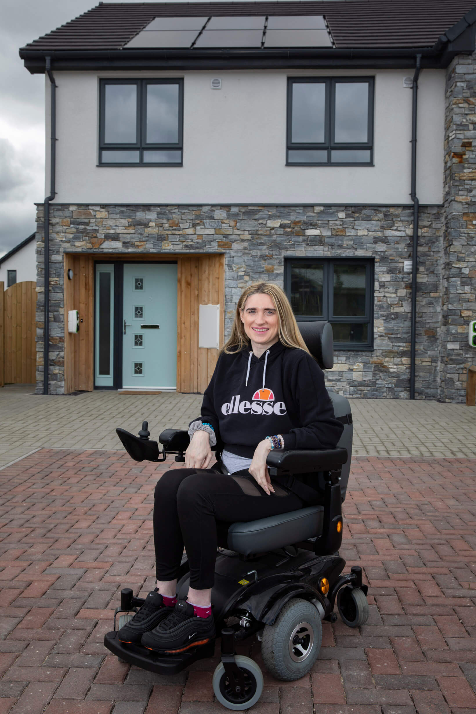 resident of glasdir housing development outside home in wheelchair