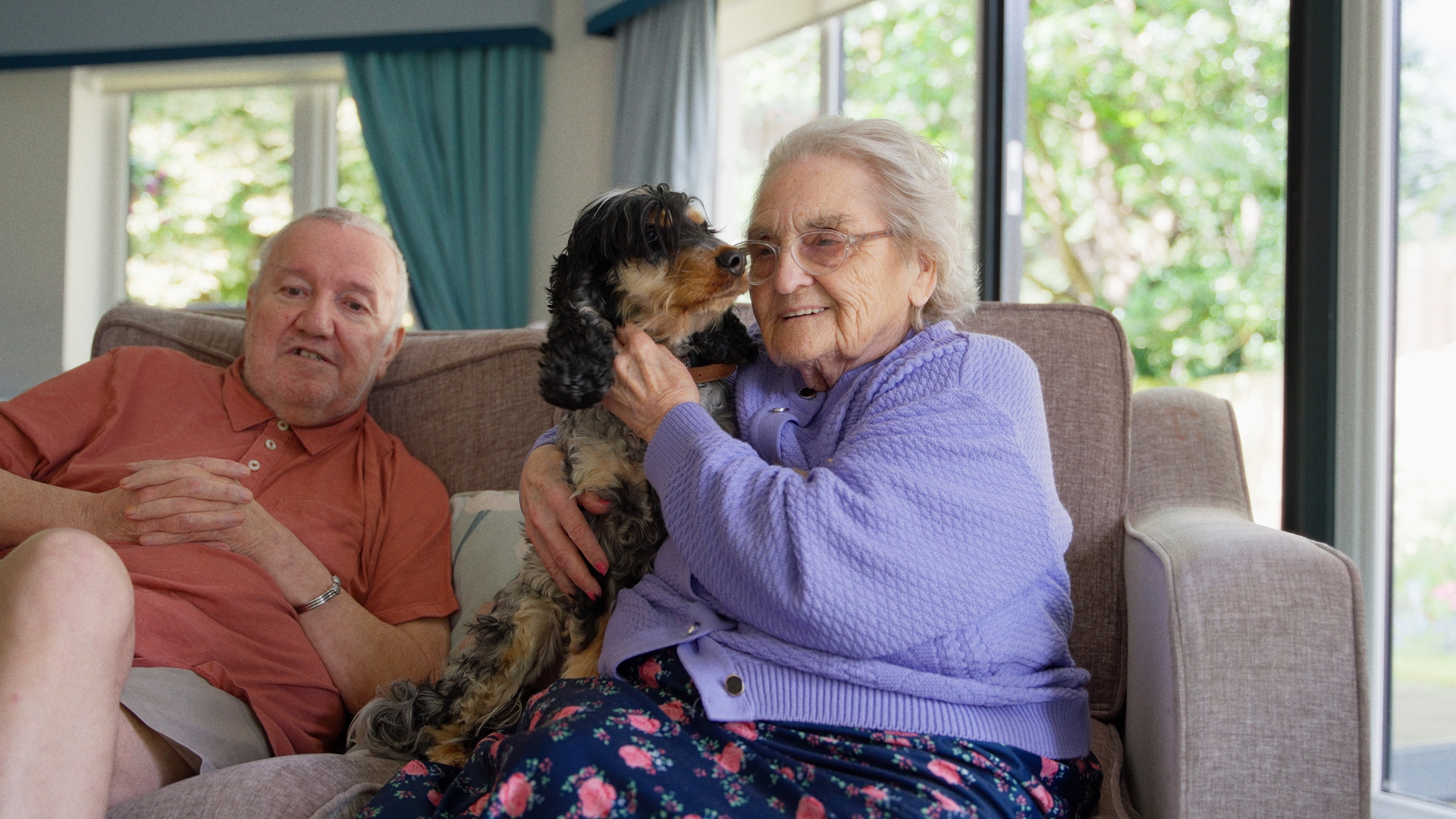 Residents at Chirk Court sitting on lounge sofa with therapy dog