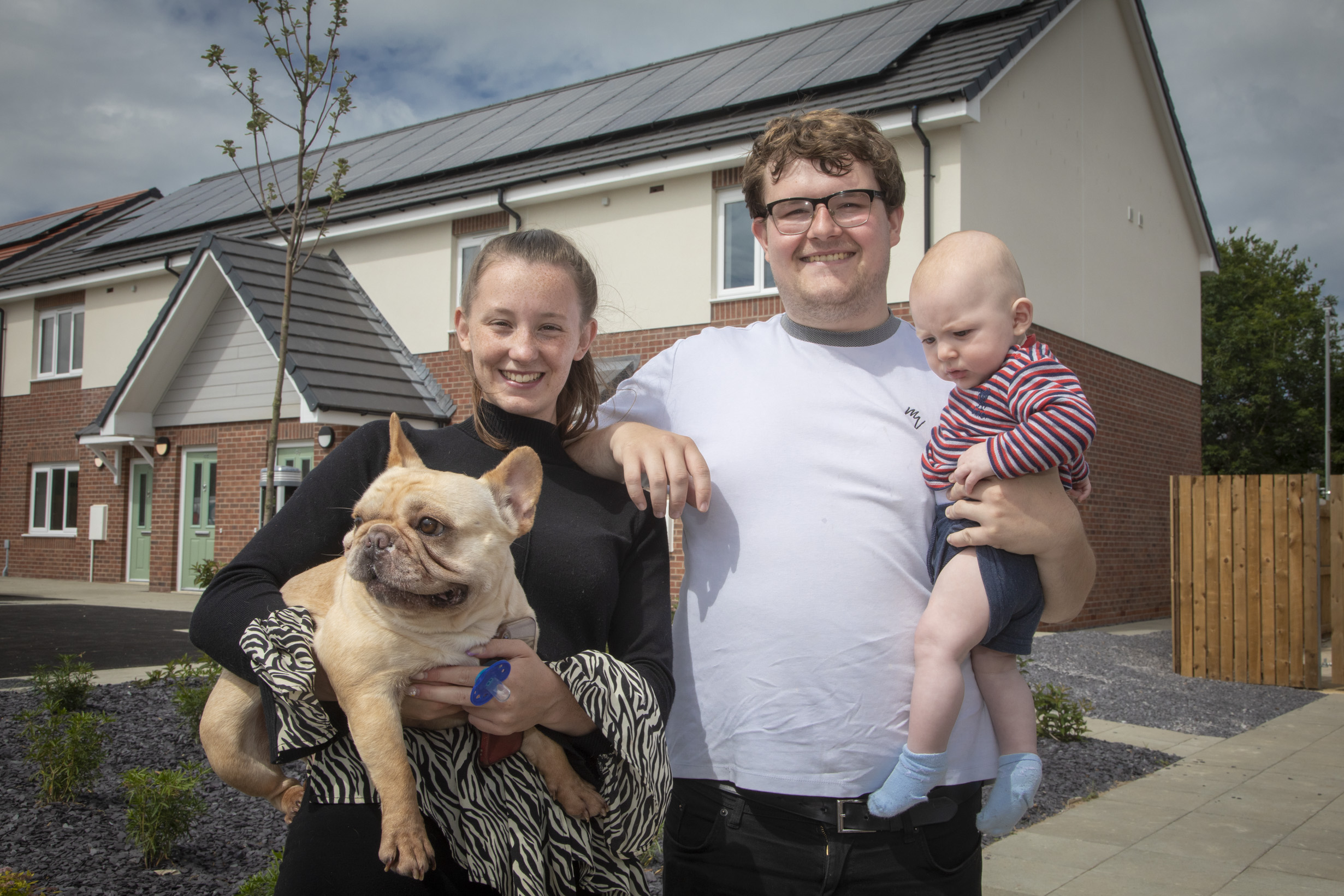 Family outside new home at Coleg Menai site, Llangefni