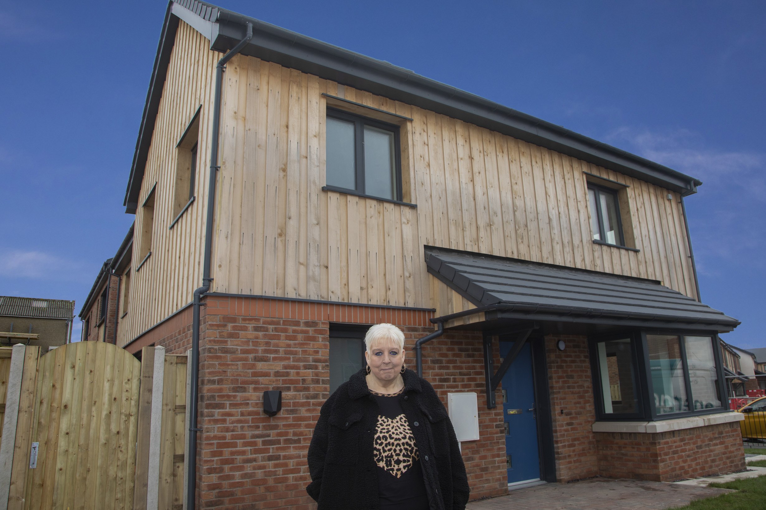 resident standing outside her new home