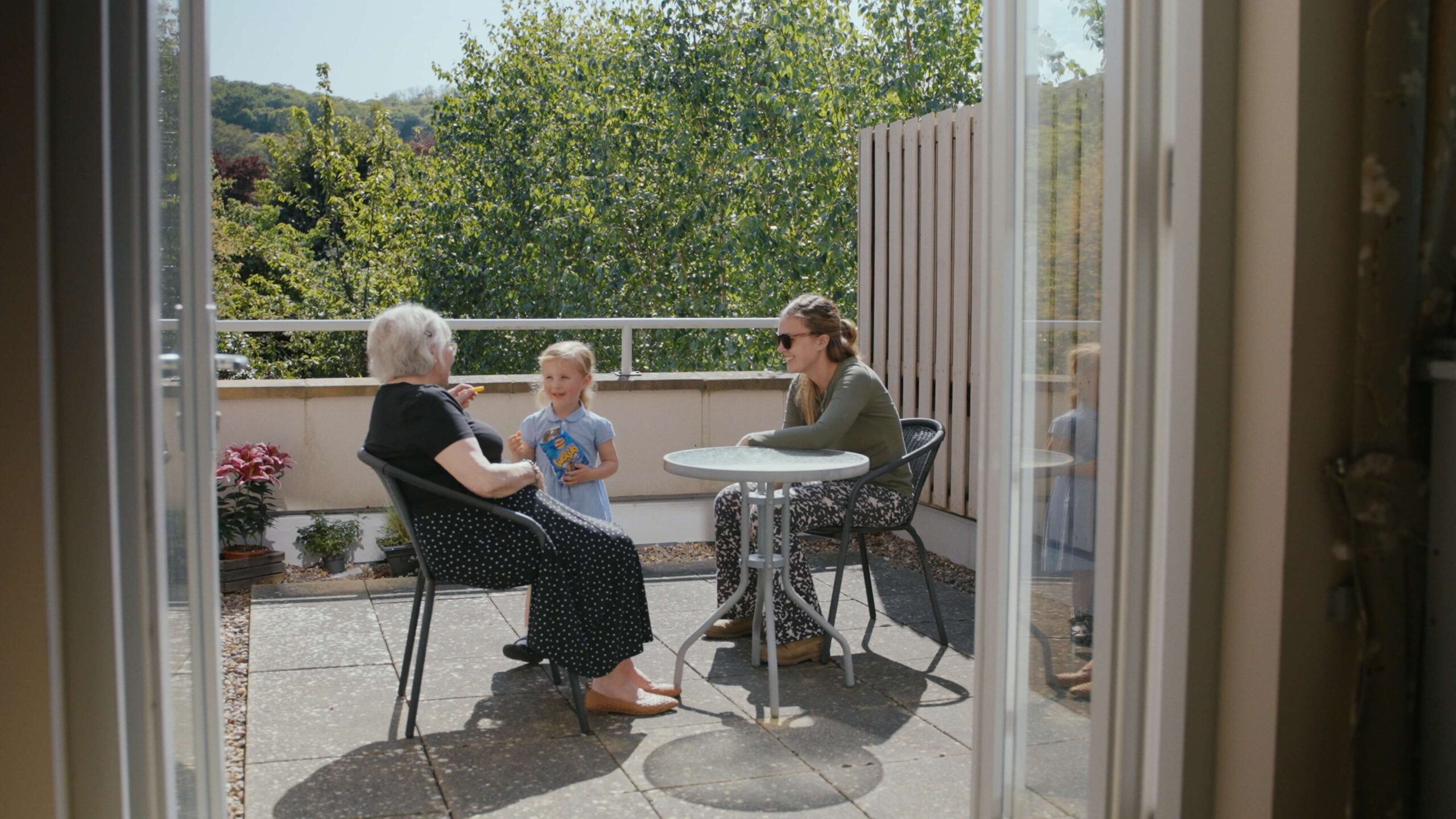 Mother, gran-daughter and daughter on the balcony of Merton Place 
