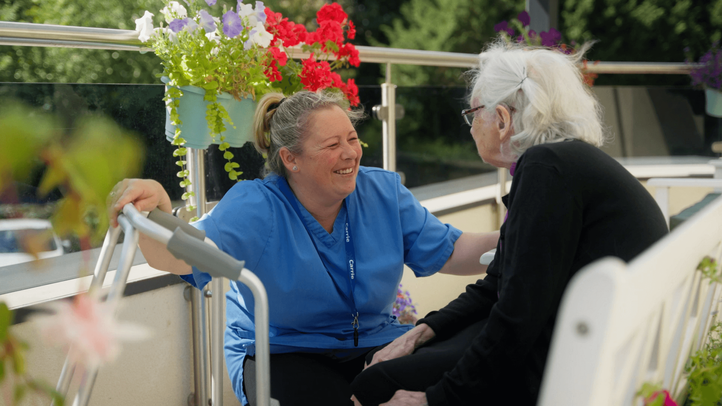 resident and staff member talking on the balcony at Chirk Court