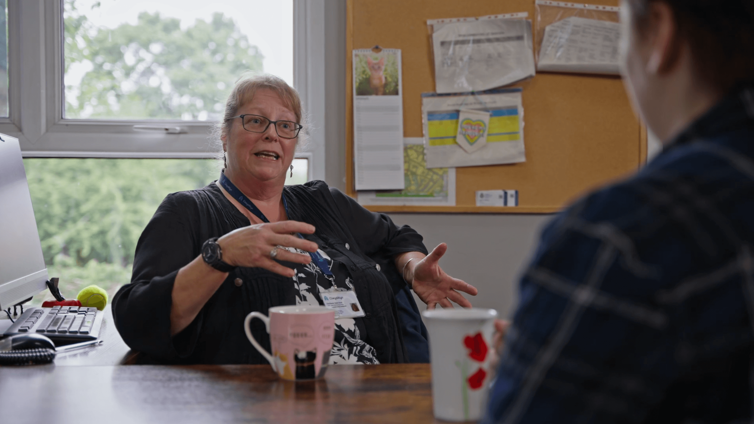 staff member and supported living resident talking with tea and coffee