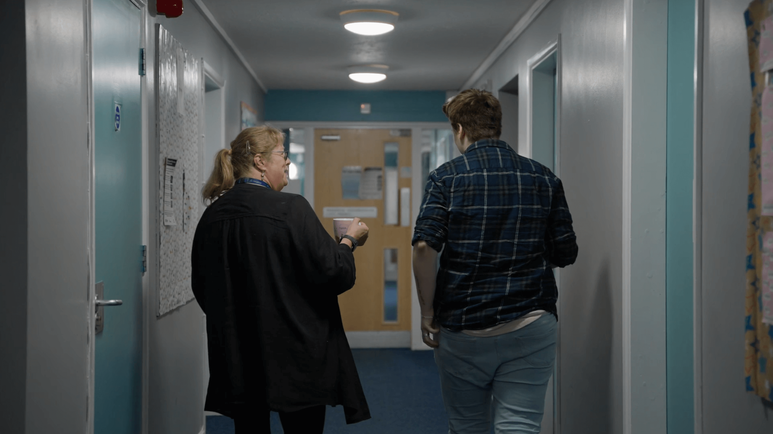 staff member and supported living resident walking down corridor