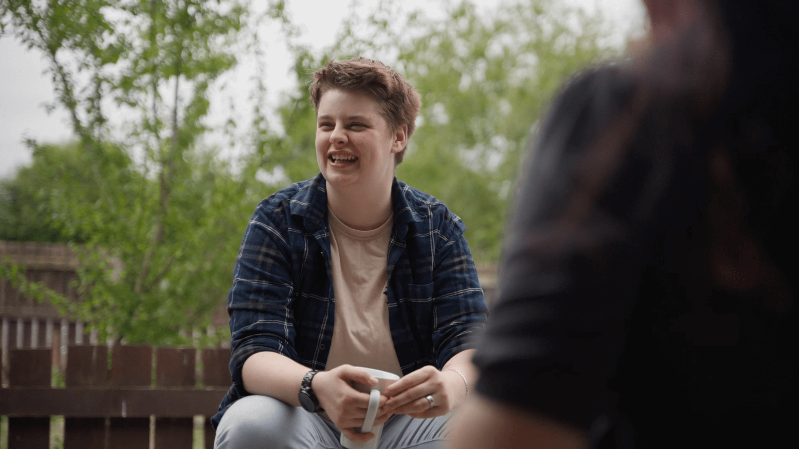 staff member and supported living resident chatting on a bench