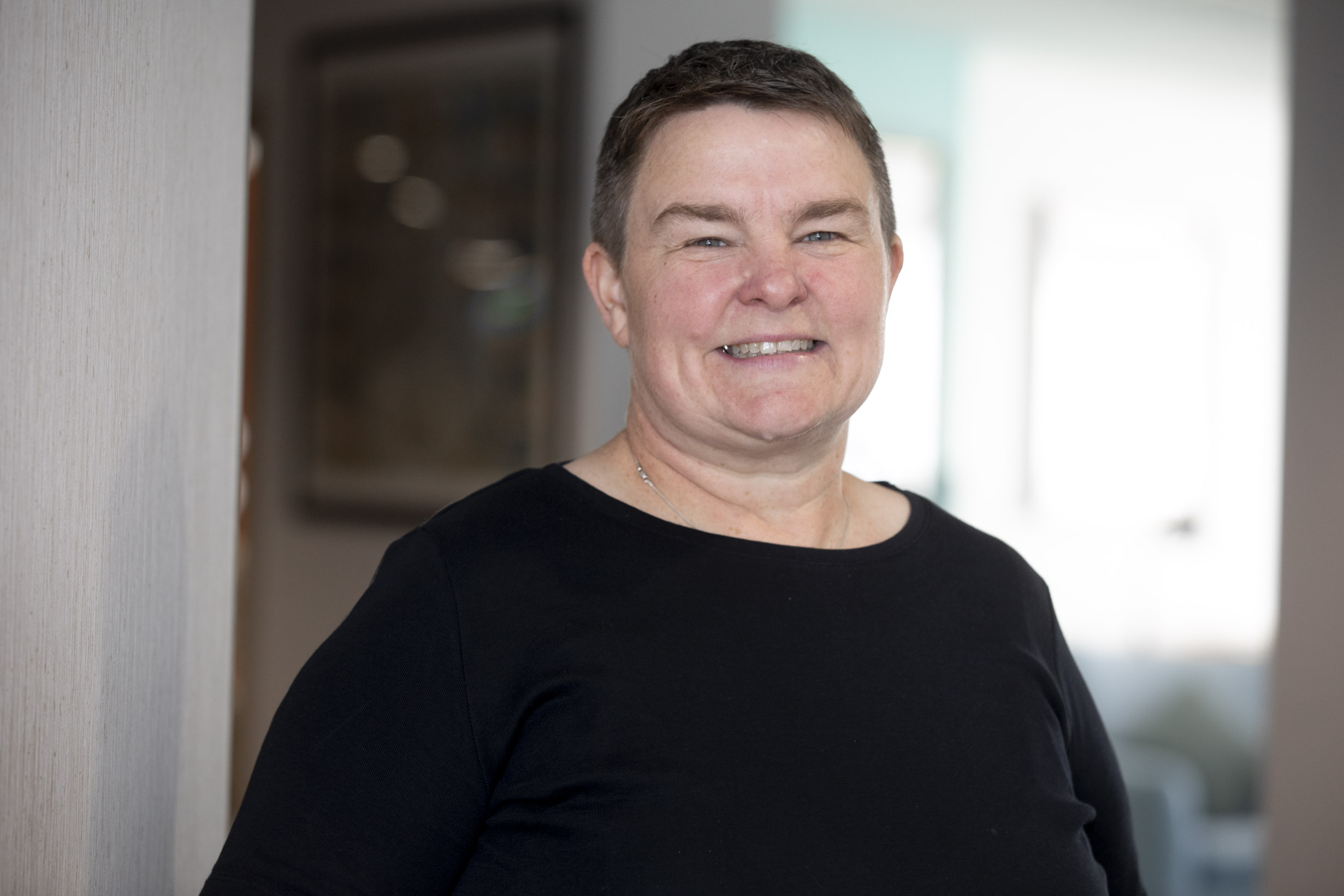 A woman in a black top smiling at the camera