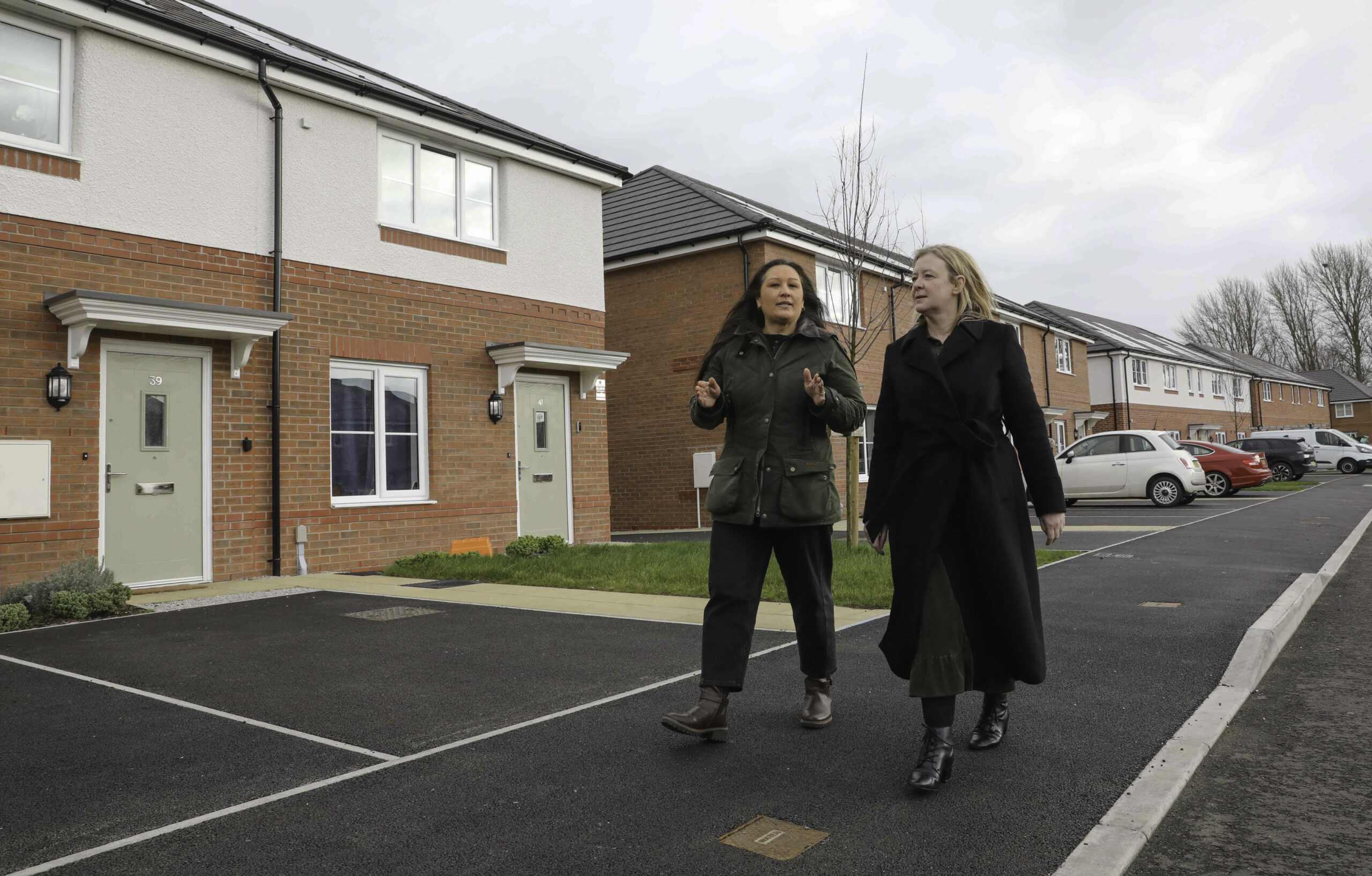 Three people visit a development of new homes.