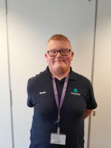 A person wearing a blue shirt smiles at the camera